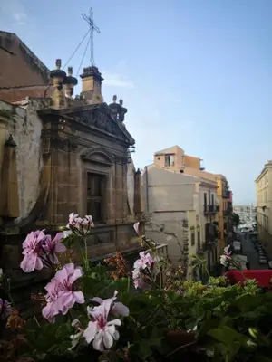 an old building with flowers in front of it at Cassàri Suite in Palermo