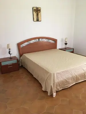 a bedroom with a large bed with two night stands at Villa Augustea in Alcamo