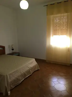 a bedroom with a bed and a window with a light at Villa Augustea in Alcamo
