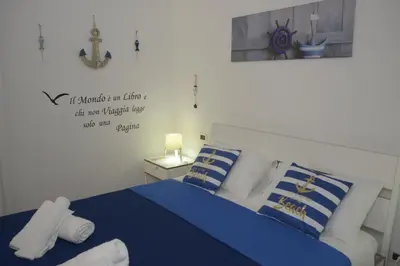 a bedroom with a bed with blue and white pillows at Normanni Homes in Palermo