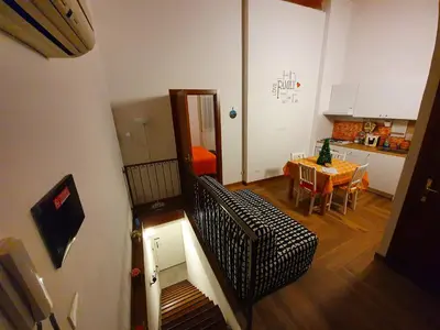 a living room with a table and a kitchen at Normanni Homes in Palermo