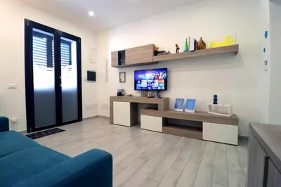 a living room with a blue couch and a tv at La Casetta di Mondello in Mondello