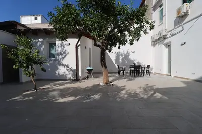 a courtyard with a tree and a table and chairs at La Casetta di Mondello in Mondello