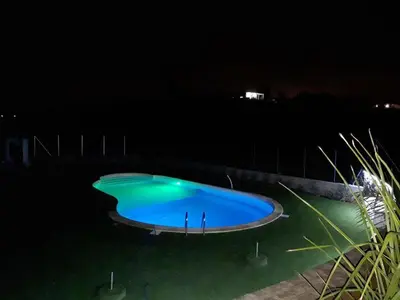 a large blue swimming pool at night at Spacious villa with sea and mountain views in Alcamo in Alcamo