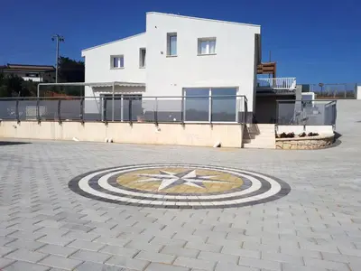 a building with a clock in the middle of a courtyard at Spacious villa with sea and mountain views in Alcamo in Alcamo