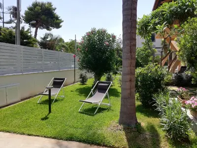 two chairs sitting on the grass in a yard at Mondello Felix - appartamenti in villa a 600m dal mare in Mondello