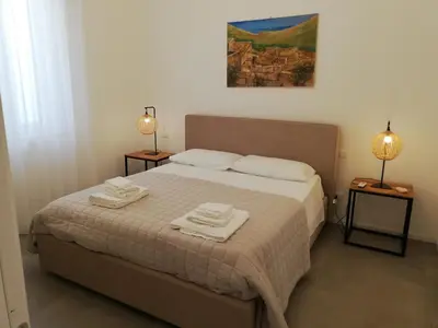 a bedroom with a bed with two towels on it at Mondello Felix - appartamenti in villa a 600m dal mare in Mondello