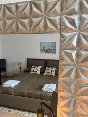 a bedroom with a large bed with a wall at Xenia House in Lascari