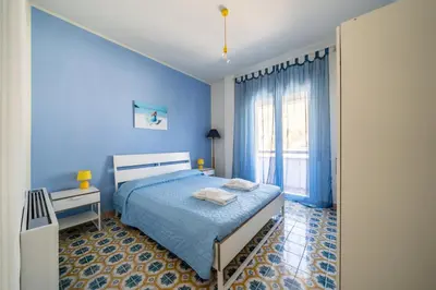 a blue bedroom with a bed and a window at La Maison De Provence - MONDELLO in Mondello