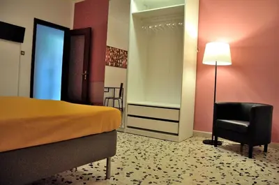 a bedroom with a bed and a chair and a lamp at Casa Rosetta in Palermo