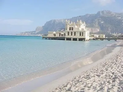 a building on the beach next to the water at Mondello Rose House in Palermo
