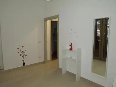 a white room with a table and a mirror at Mondello Rose House in Palermo