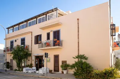 a large white building on a city street at Agave Superior Rooms in San Vito lo Capo