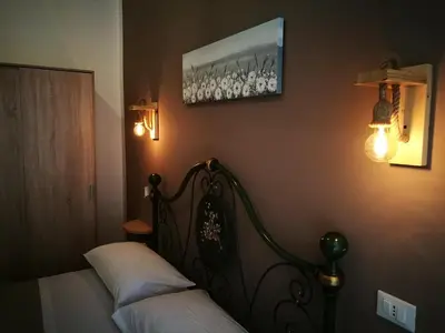 a bedroom with a bed and two lights on the wall at BELLA PALERMO in Palermo