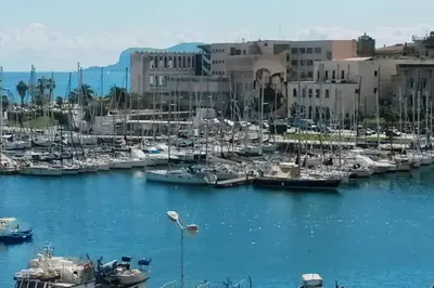 a group of boats docked in a marina with buildings at casaDamare in Palermo
