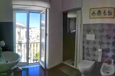 a bathroom with a toilet and a sink and a window at casaDamare in Palermo