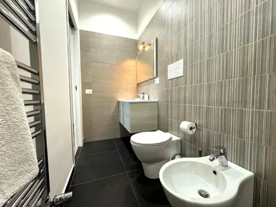 a bathroom with a white toilet and a sink at Casa di Mami in Capaci