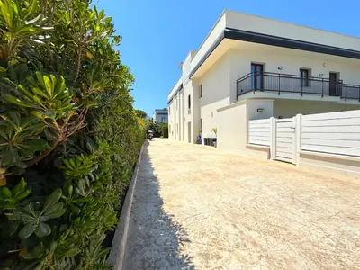 a white building with a fence next to a yard at Casa di Mami in Capaci