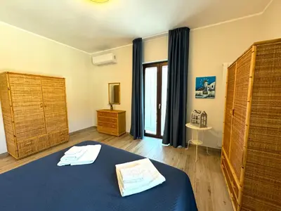 a bedroom with a blue bed and a window at Casa di Mami in Capaci