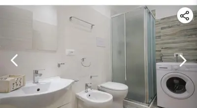 a bathroom with a sink and a washing machine at Appartamento solare in Castellammare del Golfo