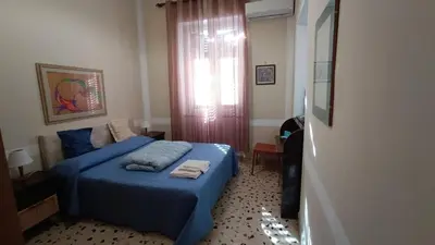 a bedroom with a blue bed and a window at Genio del Porto - Mabbonath in Palermo