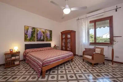 a bedroom with a bed and a chair and a window at casa Morgana in Palermo