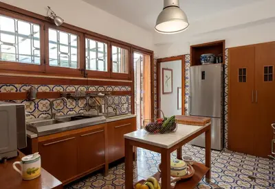 a kitchen with wooden cabinets and a sink and a table at casa Morgana in Palermo