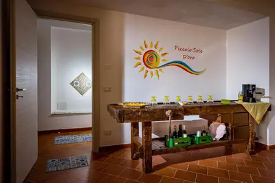 a room with a table and a sign on the wall at Piccolo Sole d'oro - appartamenti in Calatafimi