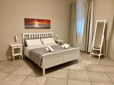 a bedroom with a large white bed with two tables at Palermo Centre - Apartments with Private Balcony or Terrace in Palermo