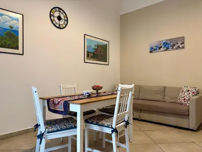 a living room with a table and chairs and a couch at Palermo Centre - Apartments with Private Balcony or Terrace in Palermo