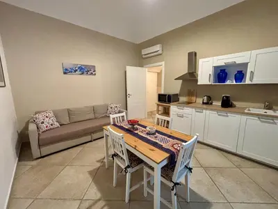 a kitchen and living room with a table and a couch at Palermo Centre - Apartments with Private Balcony or Terrace in Palermo