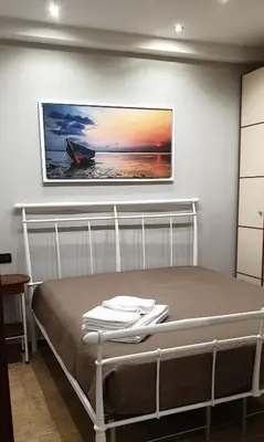 a bedroom with a bed with a picture on the wall at Casa Vacanze L'isola del Relax in Isola delle Femmine