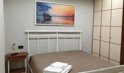 a bedroom with a bed and a painting on the wall at Casa Vacanze L'isola del Relax in Isola delle Femmine