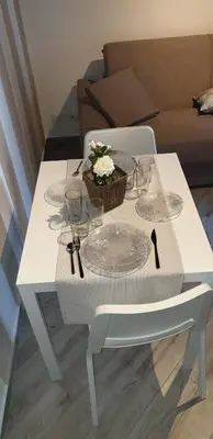a white table with glasses and a basket of flowers on it at Casa Margò in Monreale