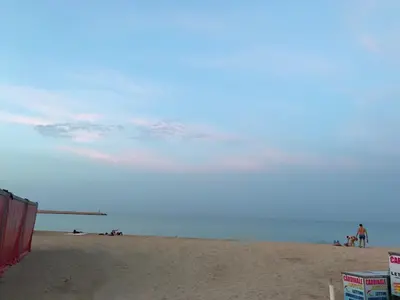 a beach with people on the sand and the ocean at B&b IL FIOCCO E LA RANDA in San Vito lo Capo