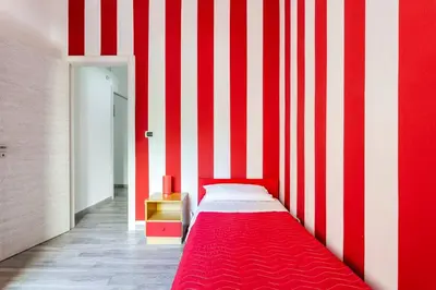a bedroom with a red and white striped wall at E.R. Apartment in Palermo
