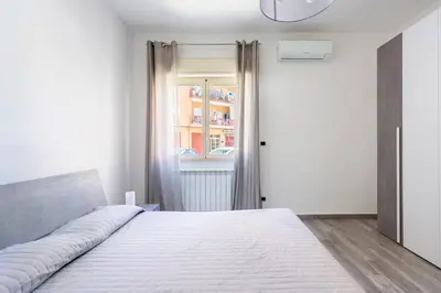 a bedroom with a large white bed and a window at E.R. Apartment in Palermo
