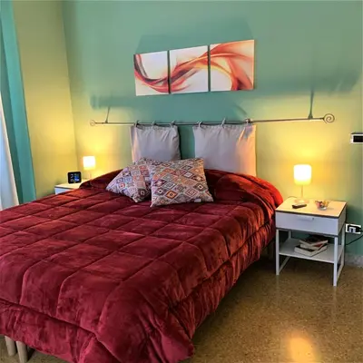 a bedroom with a bed with a red bedspread at Elerà holiday apartment in Palermo
