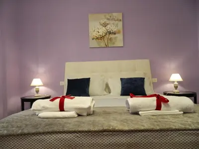 a bedroom with a large white bed with red bows at LE STANZE DI LUCA in Palermo