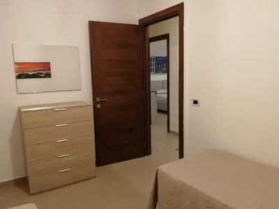 a bedroom with a dresser and a wooden door at Casa Lidia in Castellammare del Golfo