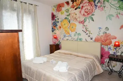 a bedroom with a bed with a floral wallpaper at Sosta dei Garibaldini in Campofelice di Roccella