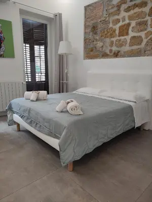 a bedroom with a large bed with towels on it at Stabile Central Studios in Palermo