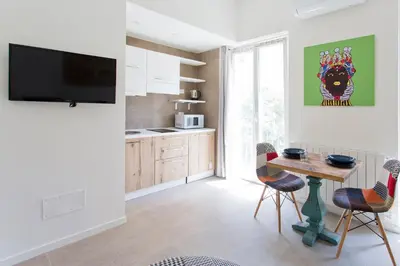 a kitchen with a table and chairs in a room at Stabile Central Studios in Palermo