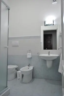 a bathroom with a sink and a toilet and a mirror at Bed And Breakfast Turi in Castelluzzo