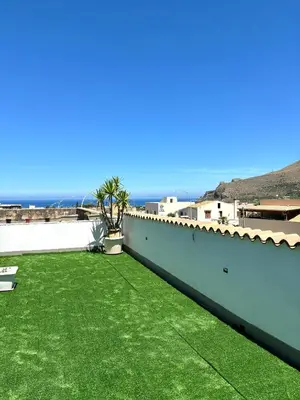a large yard with green grass on a roof at Bed And Breakfast Turi in Castelluzzo