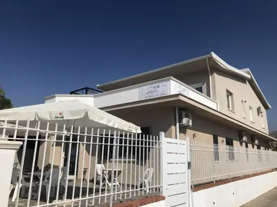 a building with a white fence in front of it at La Ruota B&B in Terrasini