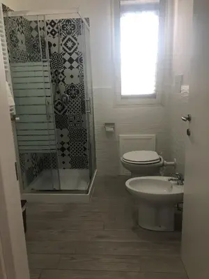 a bathroom with a toilet and a shower and a sink at La Ruota B&B in Terrasini