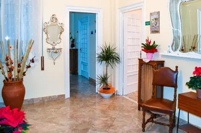 a hallway with a blue door and a chair and plants at Cheap in Center in Palermo