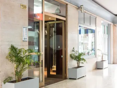 a building with two potted plants in front of a door at Cheap in Center in Palermo