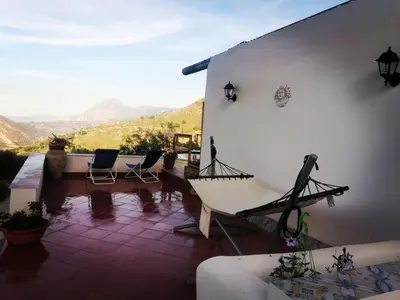 a house with a porch with a view of mountains at L'Opuntia sul lago in Caccamo